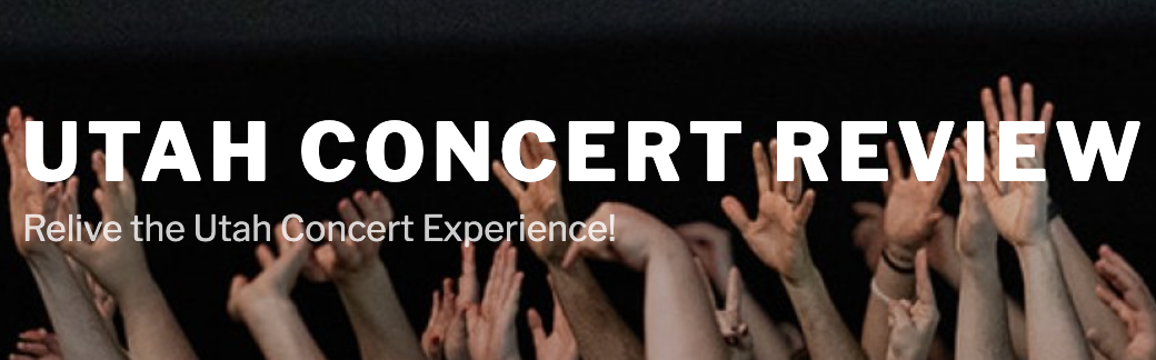 Hands in the air at a concert with utah concert review's logo overlayed